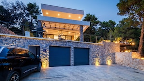 A modern two-story house with a stone facade, a car parked in the driveway, and a covered outdoor seating area. - Lovely home in Slivno with WiFi (Slivno)