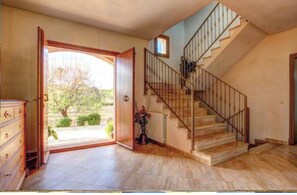 Stunning interior with a grand staircase, large doorway, and a view of the outdoors.