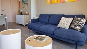 A modern living room with a blue sofa, a coffee table, and a painting on the wall. - Roses with sea views, Canyelles Brava beach, AV-10 (Rosas / Roses)