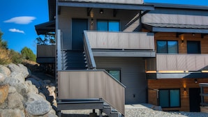 A modern two-story building with a balcony, a staircase, and a door. - Bison Meadow Lodge #4 (Gardiner)