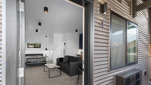 A modern interior with a sofa, coffee table, and a bed. - Bison Meadow Lodge #4 (Gardiner)