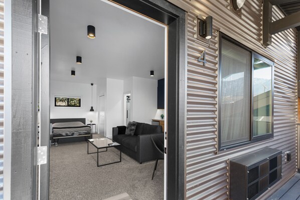 A modern interior with a sofa, coffee table, and a bed.