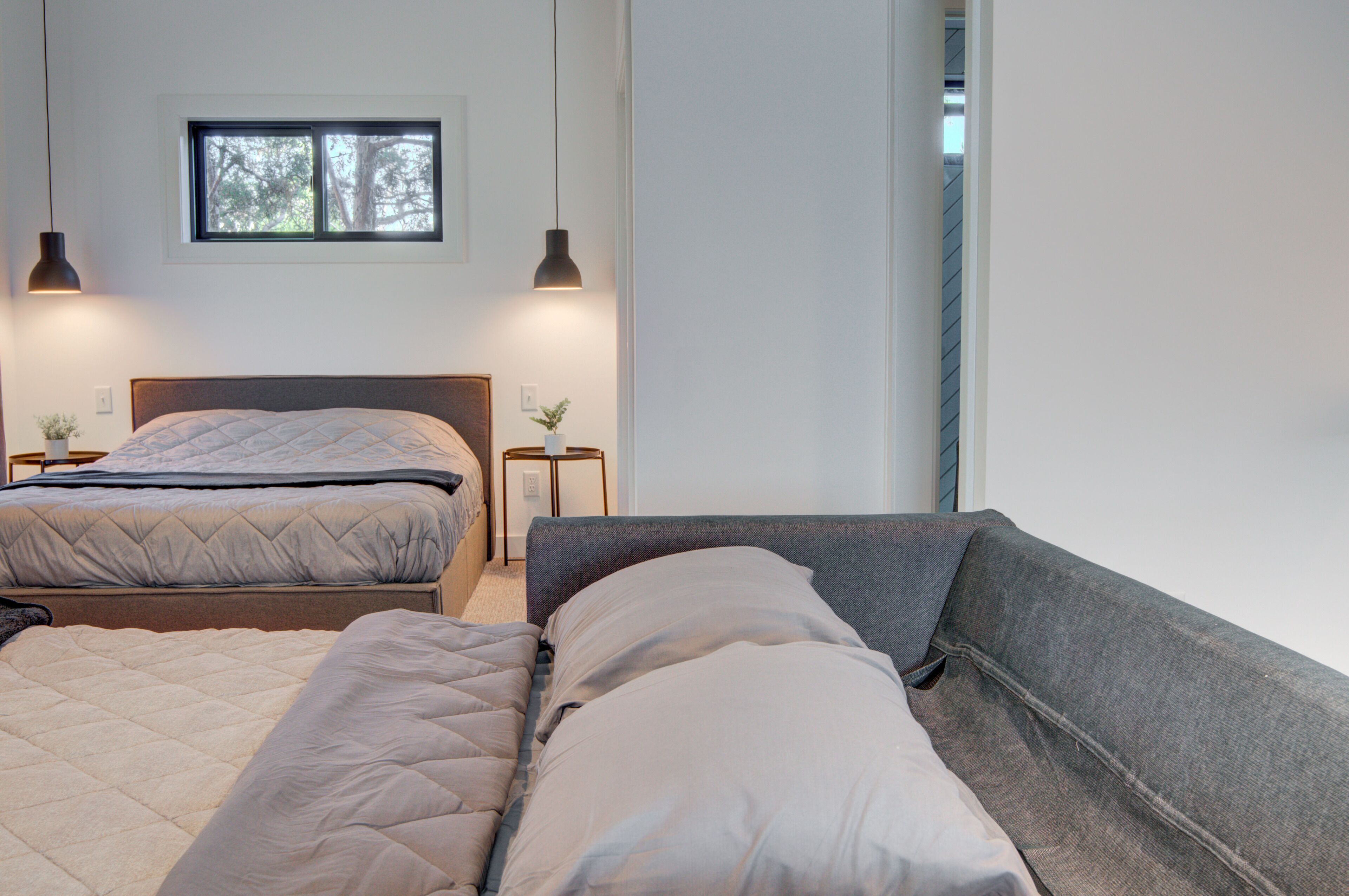 A bedroom with two beds, a window, and bedside lamps.