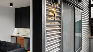 A modern kitchen with a black countertop, stainless steel appliances, and a black cabinet. - Bison Meadow Lodge #4 (Gardiner)
