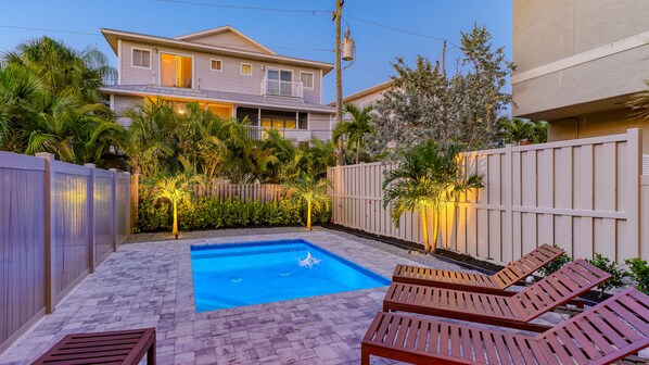 A backyard with a swimming pool, wooden deck, and lounge chairs. - Beach Dream | Home w/ Ocean Views, 2 Private Pools, Rooftop Lookout and Steps to Siesta Key Beach! (Siesta Key)