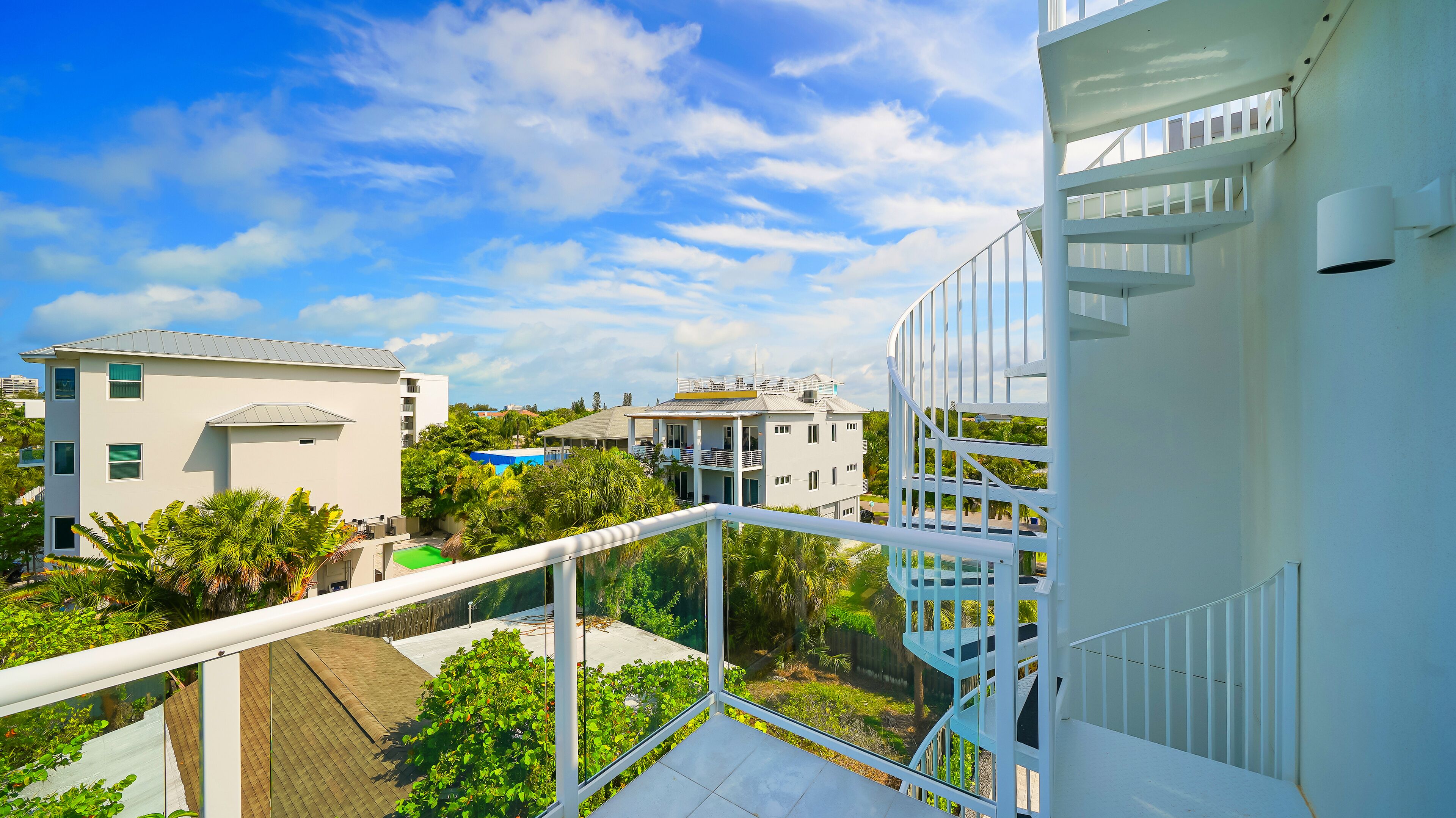 Un bâtiment moderne doté de nombreux balcons et d’un espace piscine.