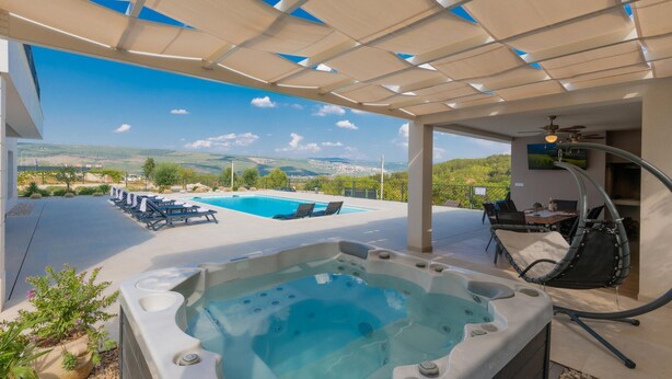 A rooftop pool area with a hot tub, lounge chairs, and a scenic view of the countryside. - Cozy home in Grubine with sauna (Grubine)