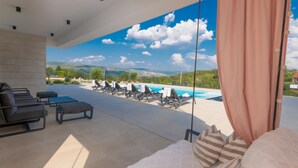 A modern outdoor lounge area with a pool, sun loungers, and a view of the landscape. - Cozy home in Grubine with sauna (Grubine)