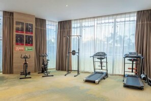 A hotel room with a gym area featuring cardio equipment, a pull-up bar, and a treadmill. - Yujinzhou Hotel (Chongqing)