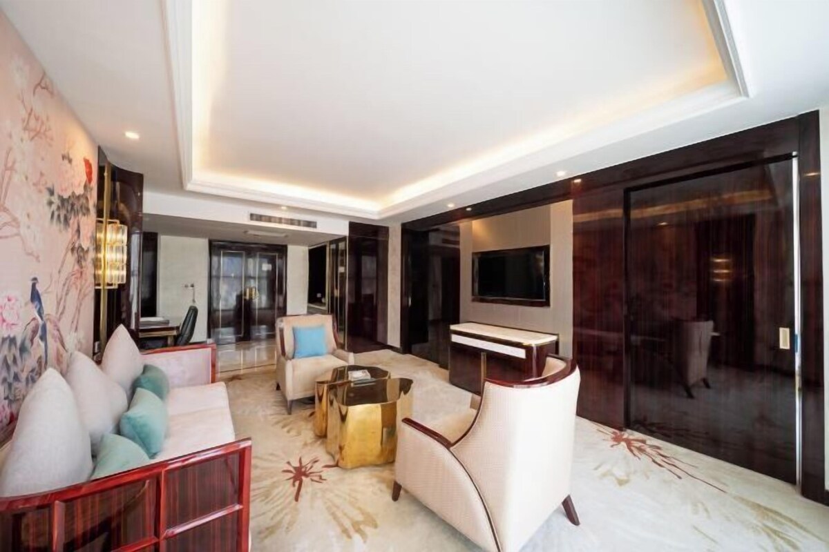 A modern living room with a sofa set, a coffee table, and a flat-screen TV.