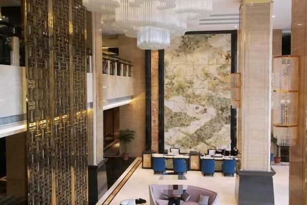 A lobby with a reception desk, a large map on the wall, and a decorative wall panel. - Yujinzhou Hotel (Chongqing)