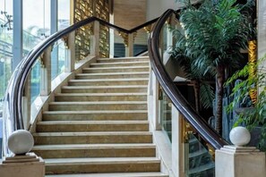 A marble staircase with a glass railing, leading to a higher floor. - Yujinzhou Hotel (Chongqing)