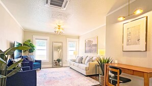 A living room with a sofa, a coffee table, a dining table, and a chandelier. - Full Kitchen // Spacious Living Room // Walk to Mineral Springs and Restaurants (Hot Springs)