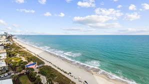 A coastal cityscape with a beach, buildings, and a clear sky. - Guest Favorite ~ Newly Renovated ~ 18th Floor Direct Ocean + SkyWheel Views (Myrtle Beach)