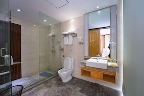 A modern bathroom with a glass-enclosed shower, a white toilet, a sink with a marble countertop, and a large mirror. - Zhao He Hotel (Nanning)