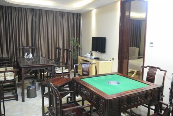 A room with a pool table, wooden chairs, a television, and a large mirror. - Zhao He Hotel (Nanning)