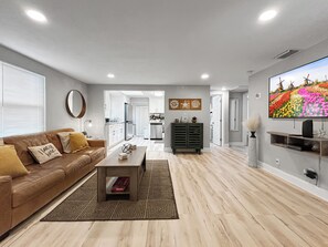 Una sala de estar moderna con un sofá, una mesa de centro y un televisor.