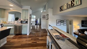 Een moderne keuken met een centraal eiland, een eethoek met een bank en een zithoek met een bank en salontafel.