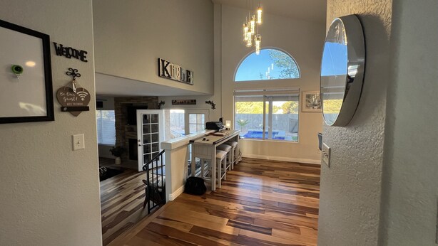 Een ruime keuken met een stenen open haard, een eethoek met een bar, en een groot raam met uitzicht op de omgeving.