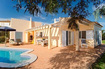 Piscine à côté de la terrasse avec chaises longues et espace barbecue