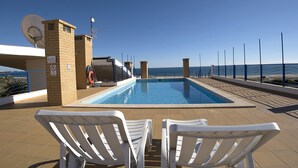 A swimming pool with two white lounge chairs, a lifebuoy, and a sign indicating no swimming. - Casa Areia Ornata, sea view terrace, beach (Lagos)