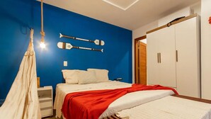 A bedroom with a bed, a wardrobe, and a hanging light fixture.