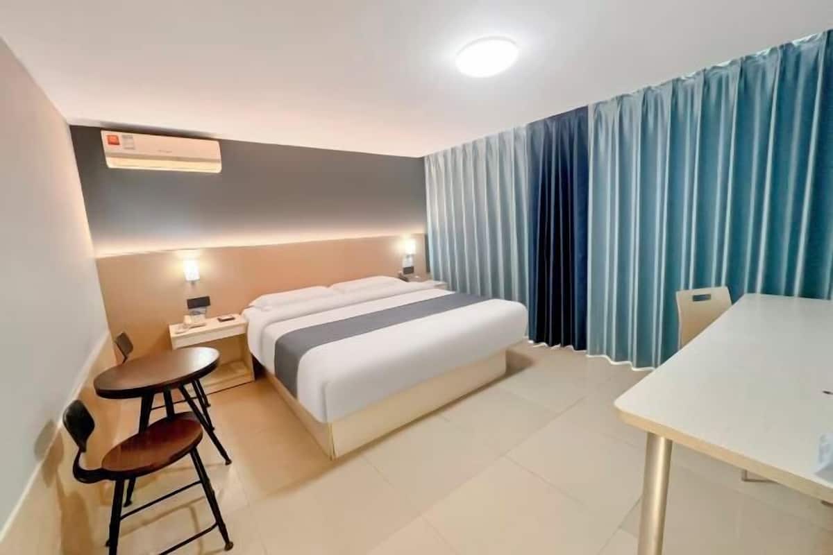 Une chambre d’hôtel comprenant un lit, des tables de chevet, un bureau et une chaise.