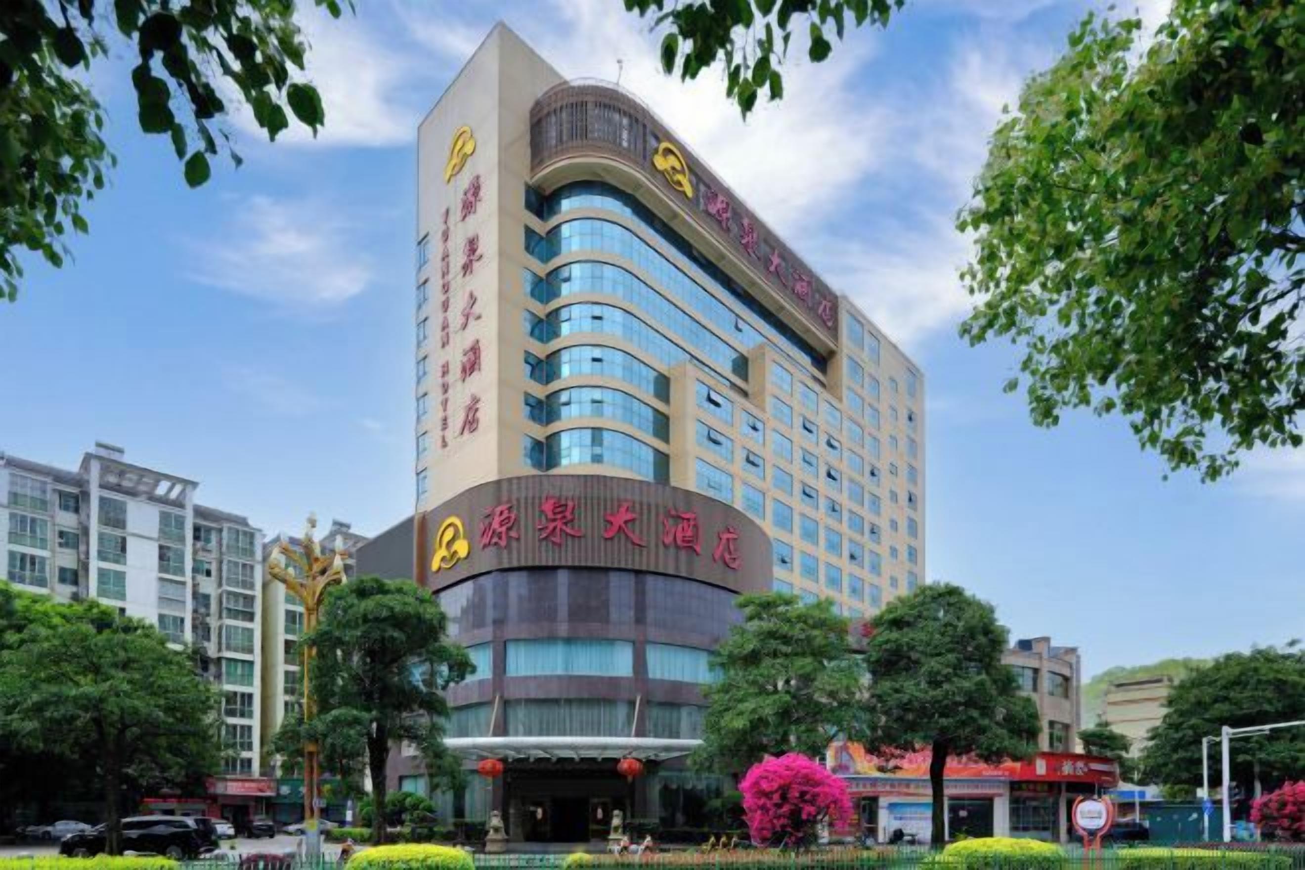 A multi-story hotel with a curved facade, large windows, and a prominent entrance.