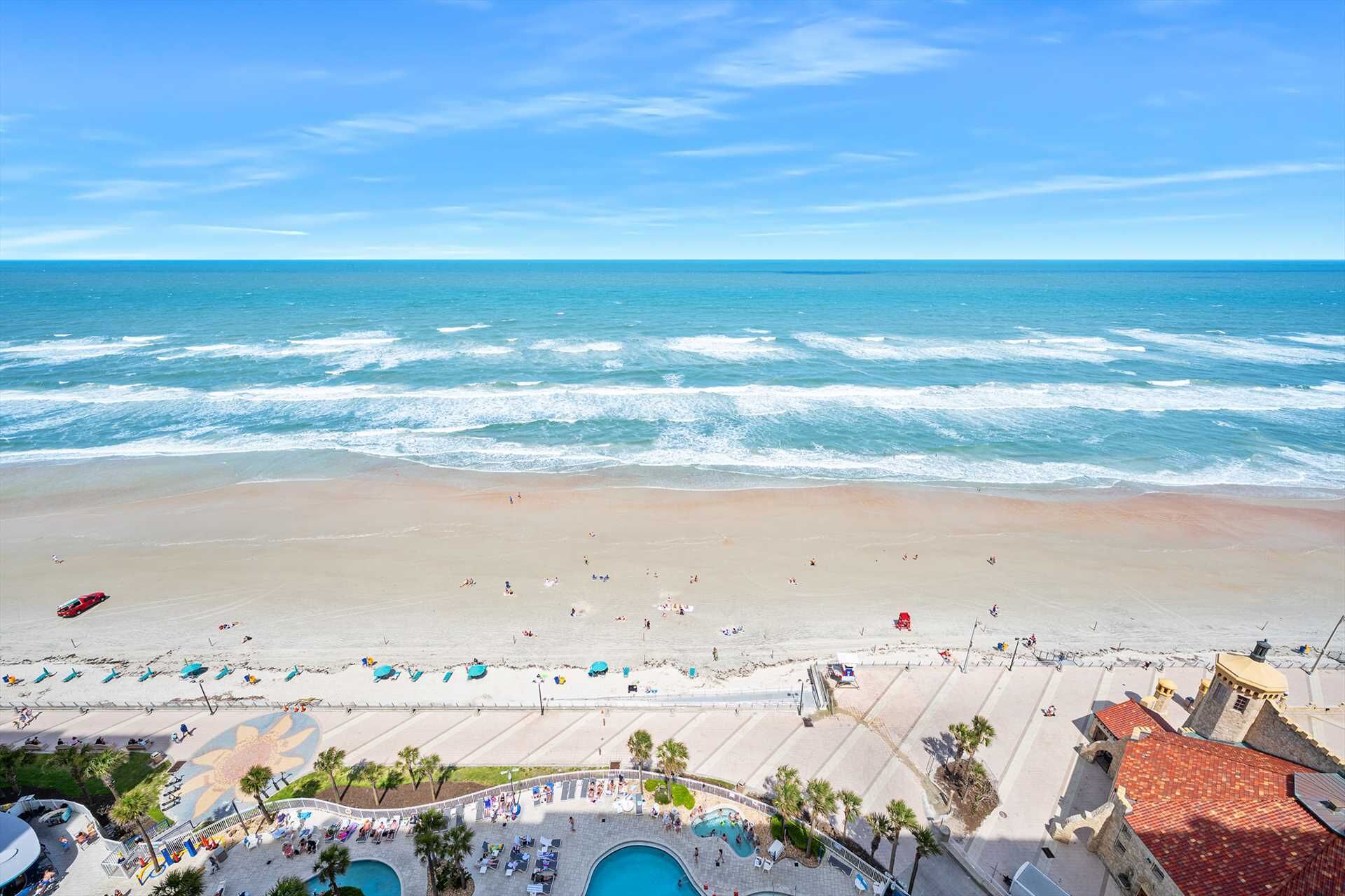 Un complejo turístico en la playa con zona de piscina, sombrillas y vistas al océano.
