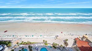 A beach resort with a pool area, beach umbrellas, and a view of the ocean. - Luxury 18th Floor 1 BR Condo Direct Oceanfront Wyndham Ocean Walk Resort Daytona Beach | 1808 (Daytona Beach)