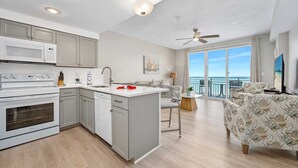 A modern kitchen with a central island, a dining area with a view, and a balcony with a view. - Luxury 18th Floor 1 BR Condo Direct Oceanfront Wyndham Ocean Walk Resort Daytona Beach | 1808 (Daytona Beach)