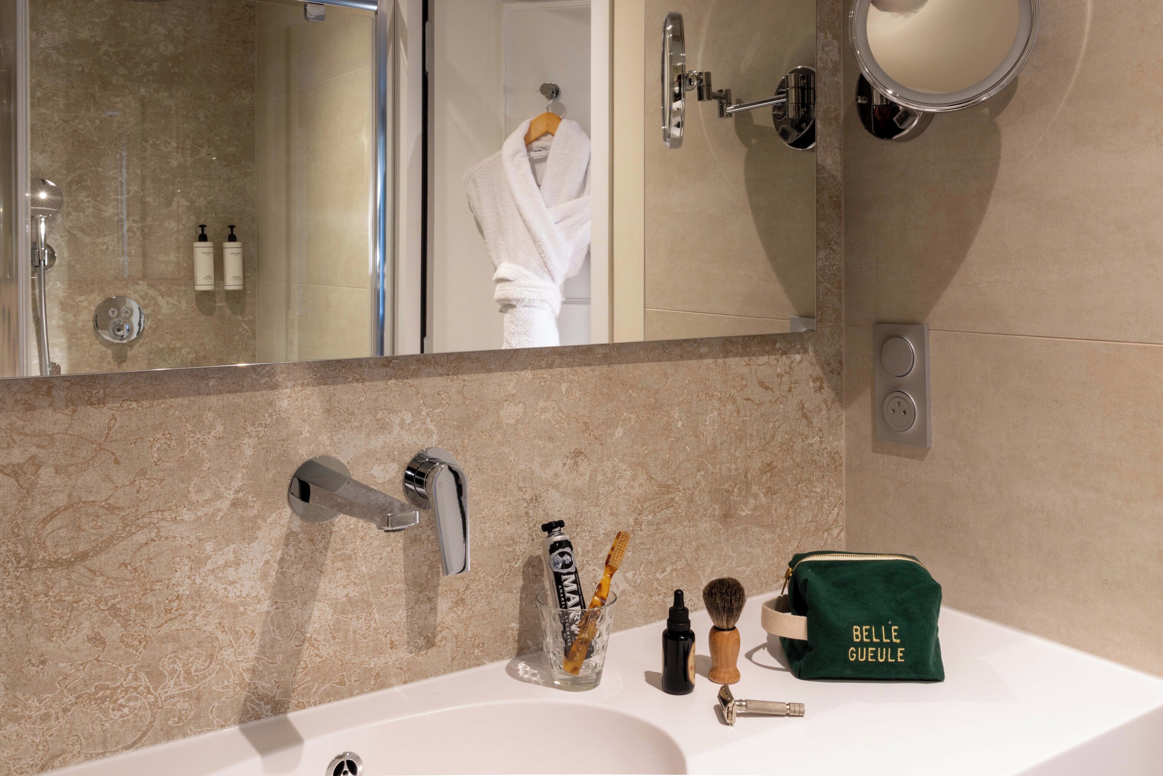 Une salle de bain équipée d’un lavabo, d’un miroir et d’articles de toilette.