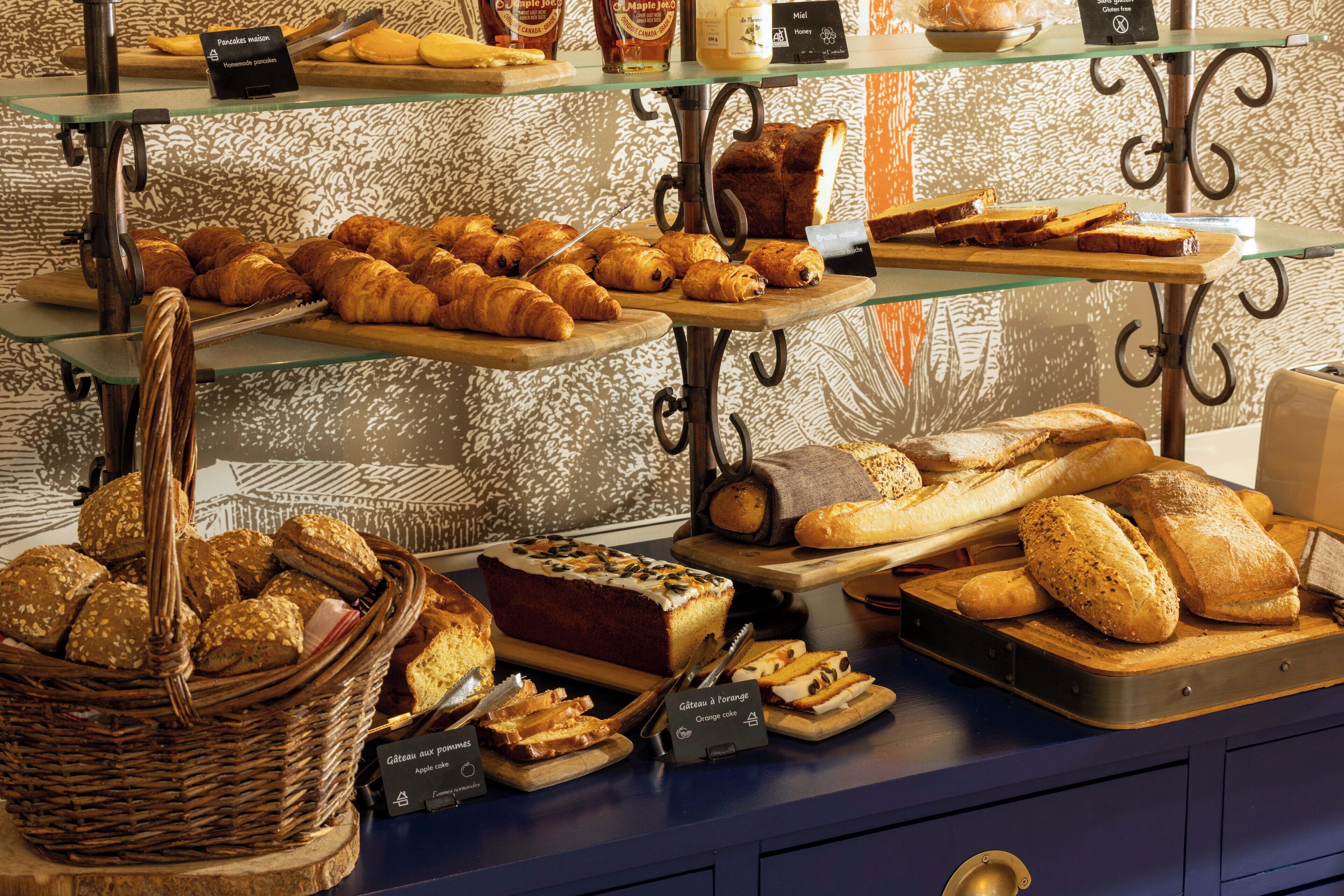 Una vitrina de panadería con panes y pasteles varios.