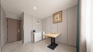 Una habitación con una cama, una mesita de noche, una ventana y una puerta.
