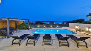 A rooftop pool area with lounge chairs and a view of the sea. - Amazing apartment in Kastel Gomilica (Kastel Gomilica)