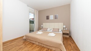 A bedroom with a bed, bedside tables, and a view through a glass door. - Amazing apartment in Kastel Gomilica (Kastel Gomilica)