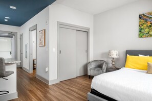 Une chambre d’hôtel moderne, équipée d’un lit, d’un bureau et d’une chaise.