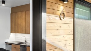 Eine moderne Küche mit Holzschränken, einer schwarzen Arbeitsplatte und einem Edelstahl-Spülbecken.
