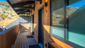 Eine Holzterrasse mit Blick auf eine gebirgige Landschaft.