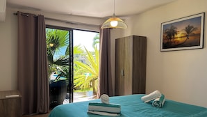 Een hotelkamer met een bed, een kledingkast, een bureau en uitzicht op het omliggende landschap.