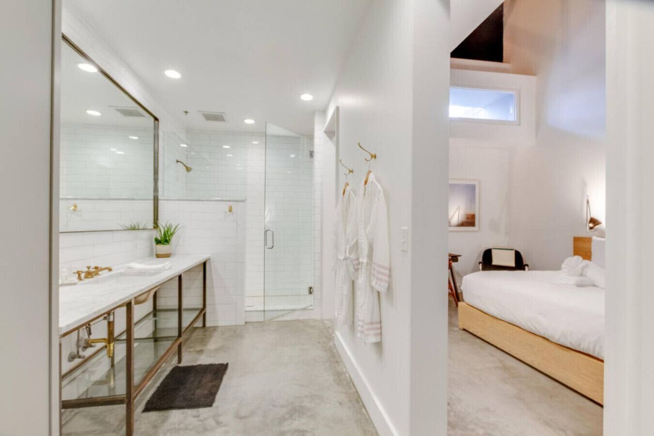 A modern bathroom with a glass shower enclosure, a vanity with a mirror, and a walk-in shower.