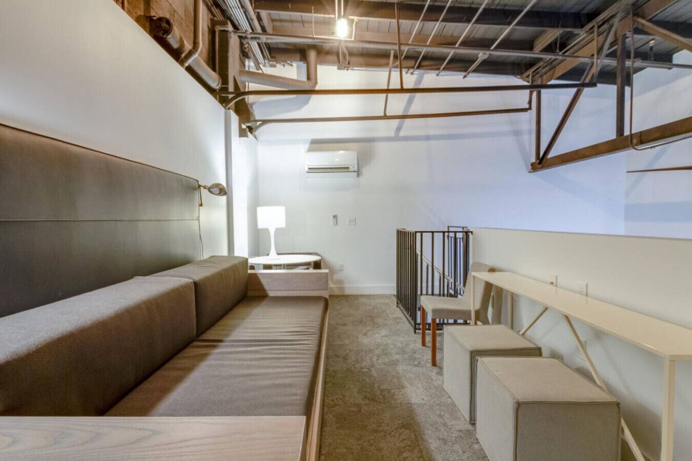 A modern, minimalist room with a sofa, a small table, and a chair.