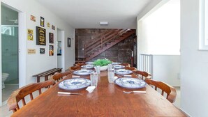 Un comedor con una larga mesa de madera preparada para una comida, rodeado de sillas.