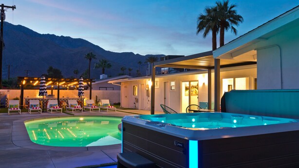 A hot tub with blue LED lights, a pool, lounge chairs, and a mountain backdrop. - Located in the famous Movie Colony neighborhood close to Downtown. (Palm Springs)