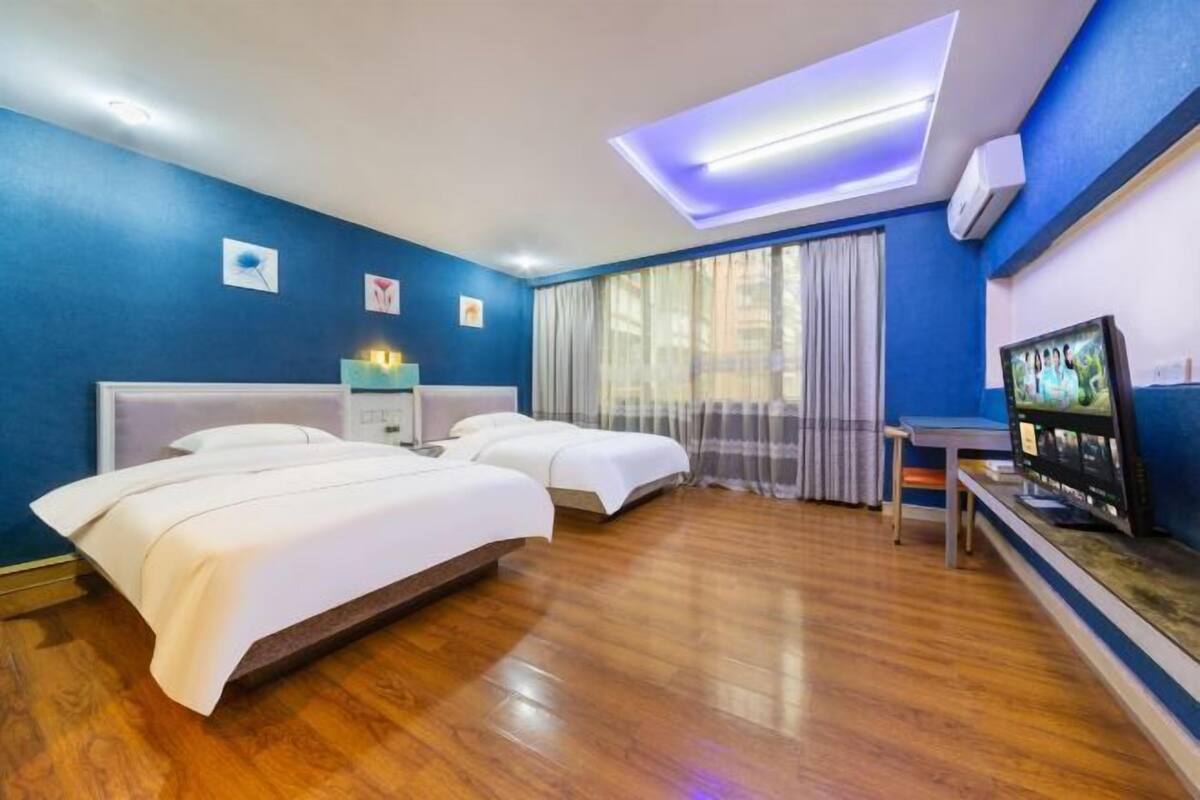 Een hotelkamer met twee bedden, een televisie, een bureau en een dakraam.