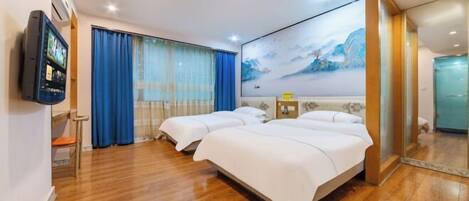 A hotel room with two beds, a TV, a painting, and a wooden floor.