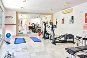 A gym with exercise equipment, blue mats, and dumbbells. - Beautiful 2BR on Calle 38-Walk to Beach & 5th Ave (Playa del Carmen)