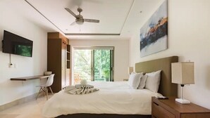 A modern bedroom with a bed, bedside table, lamp, and a TV mounted on the wall.