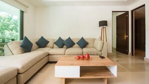 A modern living room with a beige sectional sofa, a wooden coffee table, and a floor lamp.