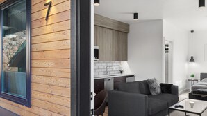 Ein modernes Interieur mit einer Holzwand, einer Couch, einem Couchtisch und einer Küchenzeile.